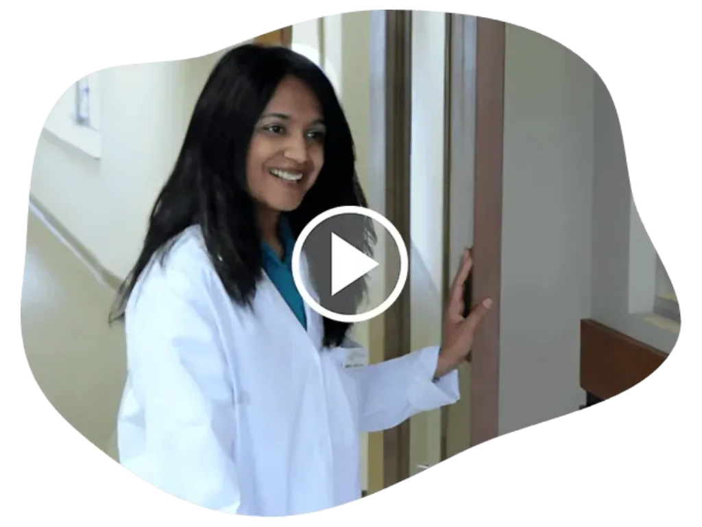 Video thumbnail of a female doctor in a white coat in a hallway